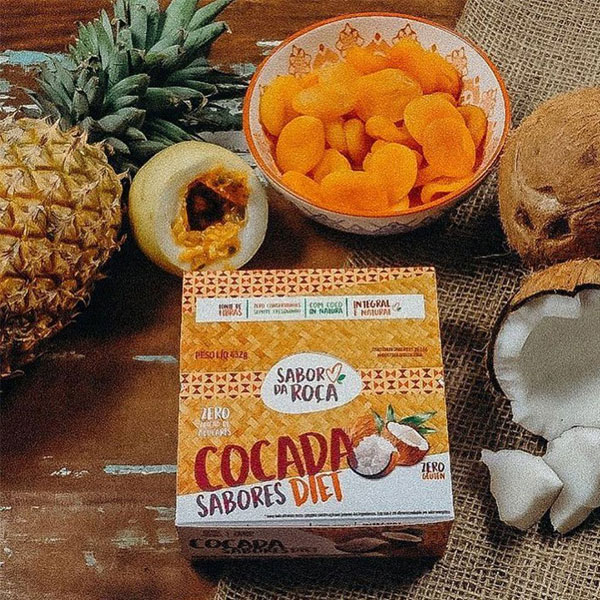 Mesa com frutas espalhadas e uma caixa de cocada diet