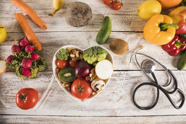 Bowl em formato de coração repleto de frutas e verduras dentro