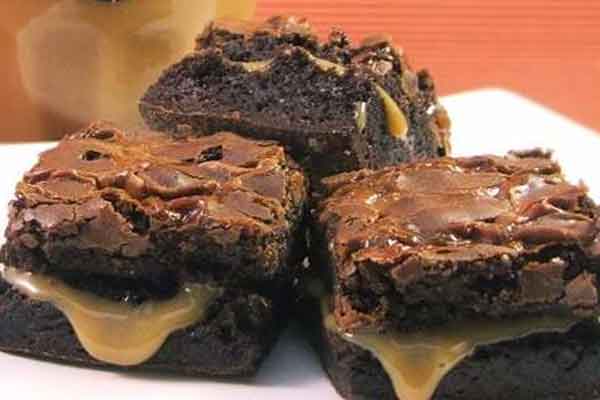 Pedaços de brownie com recheios de doce de leite com café saindo pra fora do doce